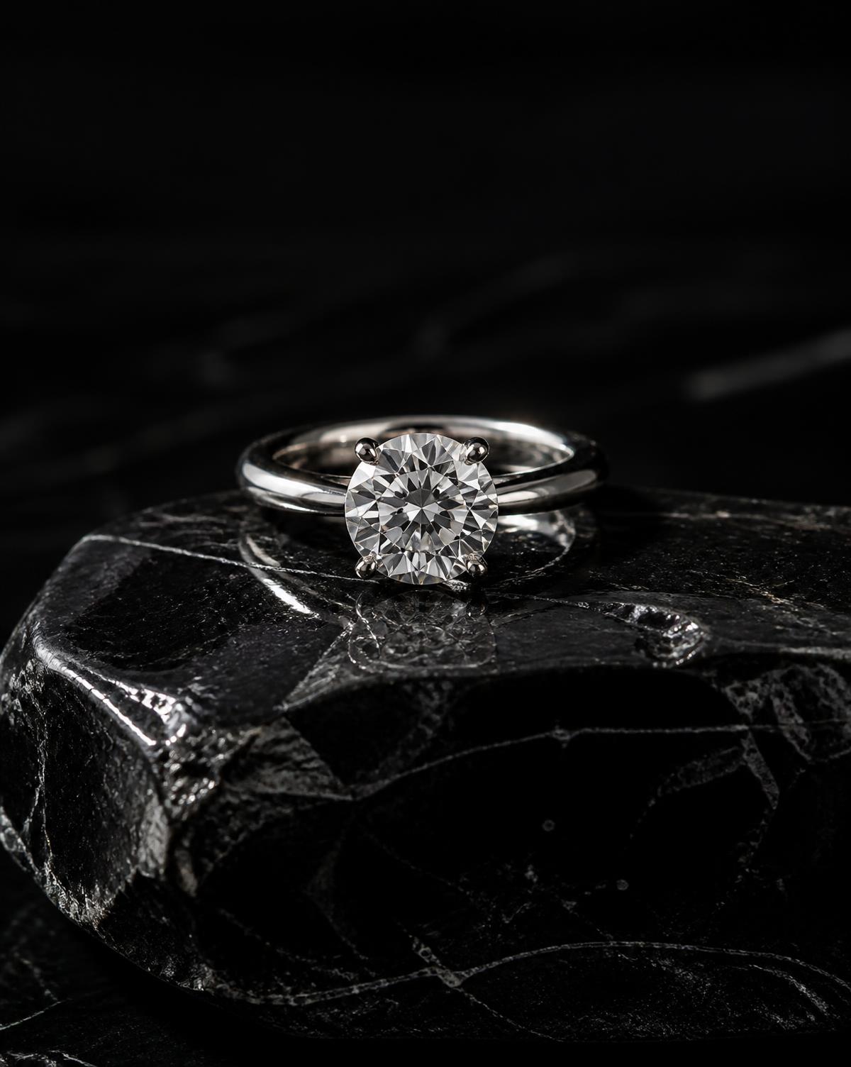 Round brilliant-cut diamond solitaire ring on black stone